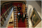 President George W. Bush, Laura Bush and India's Prime Minister Dr. Manmohan Singh and Mrs. Gursharan Kaur walk down the stairs to the State Dining Room, Monday, July 18, 2005 at the White House, for the official dinner in honor of the visit by India's Prime Minister Dr. Manmohan Singh. White House photo by Eric Draper