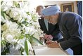 India's Prime Minister Dr. Manmohan Singh is accompanied by U.S. Department of State Chief of Protocol Ambassador Donald Ensenat, Monday, July 18, 2005, as Singh signs the guest book upon his arrival to the White House. 