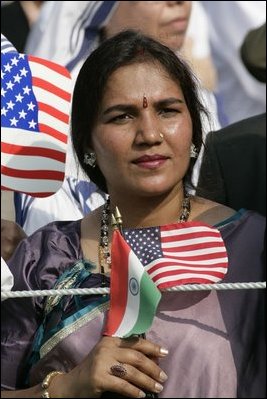 A guest attending the official arrival of India's Prime Minister Dr. Manmohan Singh, holds an American and India flag, Monday, July 18, 2005, on the South Lawn of the White House. 