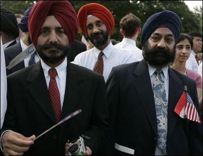 Guests wait for the official arrival ceremony of India's Prime Minister Dr. Manmohan Singh, holds an American and India flag, Monday, July 18, 2005, on the South Lawn of the White House. 