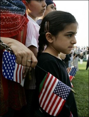 A young girl waits for the official arrival of India's Prime Minister Dr. Manmohan Singh, holds an American and India flag, Monday, July 18, 2005, on the South Lawn of the White House. 