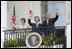 President George W. Bush, Laura Bush and Prime Minister Junichiro Koizumi of Japan wave from the Truman Balcony at the conclusion of the official arrival ceremony Thursday, June 29, 2006.