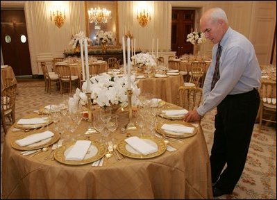 Last minute checks and adjustments are made on the table arrangements in the State Dining Room, Wednesday, Nov. 2, 2005, in preparations for the official dinner for the Prince of Wales and Duchess of Cornwall at the White House.